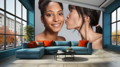 Portrait of two multinational half-naked women smiling and kissing Wall mural