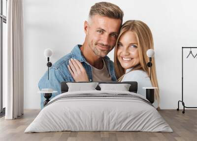 Portrait of young caucasian couple man and woman in basic clothing smiling and hugging together Wall mural