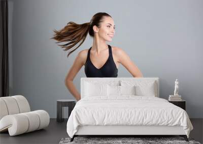 Positive cheerful fitness woman warming up and turning her head Wall mural