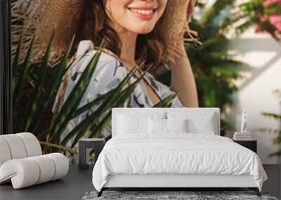 Positive happy young beautiful woman at the beach walking in a beautiful sunny morning over tropical plants. Wall mural