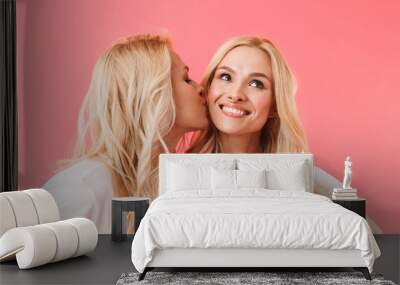 Pretty blonde woman kissing her pretty pleased sister Wall mural