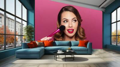 Pretty caucasian lady with make up brush looking aside Wall mural