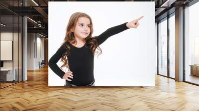 Pretty curly little girl standing and pointing away Wall mural