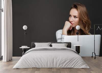 Serious lady using laptop over dark background Wall mural