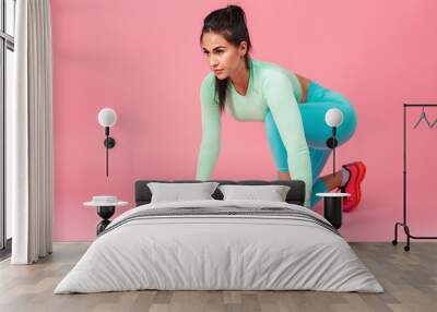 Serious young sports fitness woman isolated over pink wall background. Wall mural