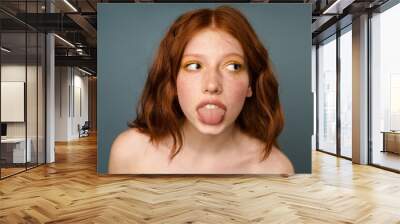 Shirtless ginger woman showing her tongue and looking aside Wall mural