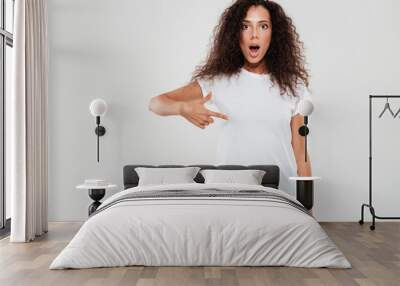 Shocked young woman with curly hair Wall mural