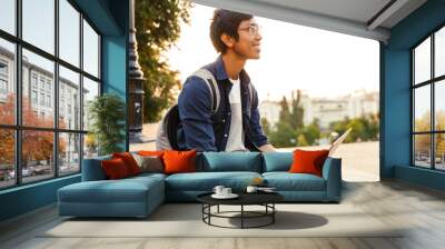 Side view of Smiling asian male student in eyeglasses Wall mural