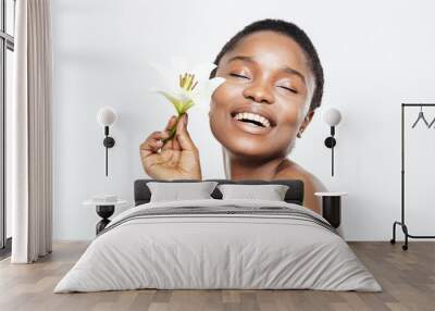 Smiling afro american woman holding flower Wall mural