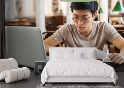 Smiling asian teenager student studying Wall mural