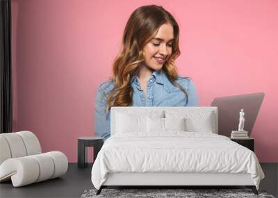 Smiling blonde woman wearing in denim shirt using laptop computer Wall mural