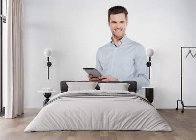 Smiling business man holding tablet computer Wall mural