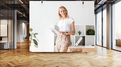 Smiling businesswoman holding folder Wall mural