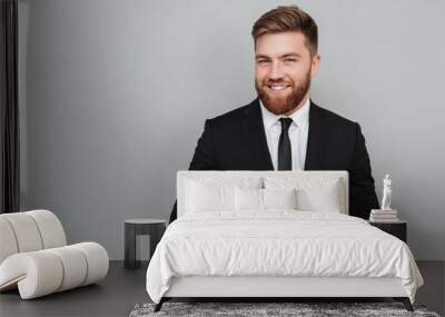 Smiling handsome businessman in suit standing and laughing Wall mural