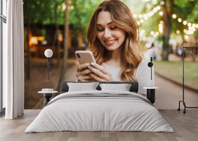 smiling young girl holding mobile phone Wall mural