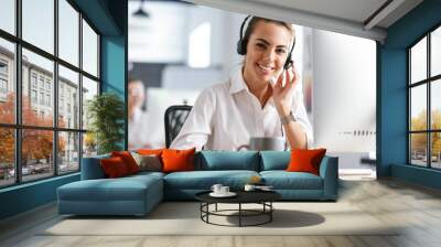 Smiling young woman wearing microphone headset Wall mural