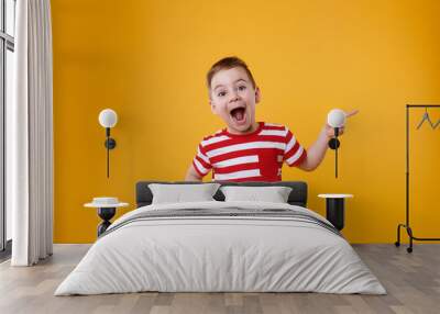 Surprised happy boy pointing fingers up at copyspace Wall mural