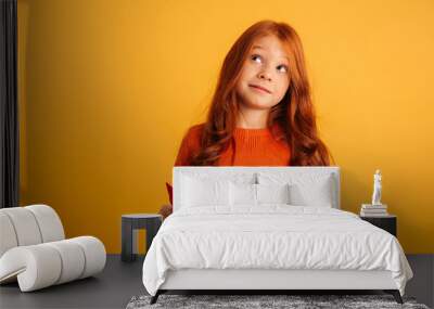 Thinking little redhead girl reading book Wall mural