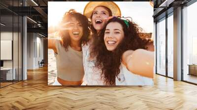 Three cheerful girls friends in summer clothes Wall mural