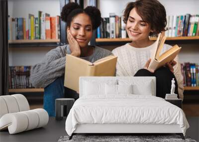 Two cheerful young girls students studying Wall mural