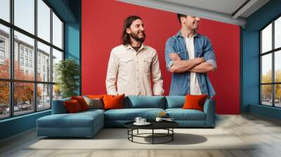 Two cheerful young men wearing casual clothes standing Wall mural