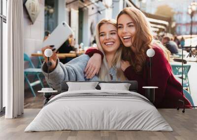 Two happy smiling girls taking a selfie Wall mural