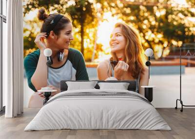 Two happy young girls having fun while sitting and talking Wall mural