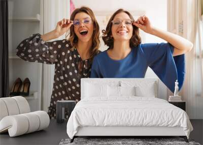 Two pretty young women shopaholics wearing glasses. Wall mural