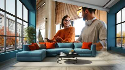 White young colleagues using gadgets while working together in office Wall mural