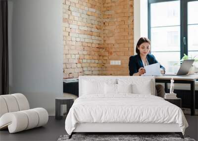 White young woman in wheelchair working with papers and laptop Wall mural