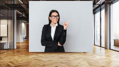 Woman in suit and eyeglasses pointing finger away Wall mural