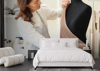 Woman measuring fabric on black dummy Wall mural