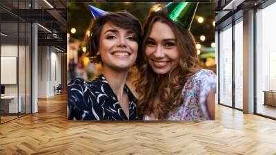 Women friends outdoors in park having fun looking camera take a selfie. Wall mural