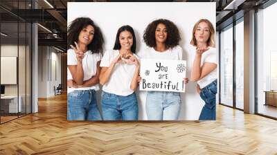 Women multiracial friends holding blank with compliments text. Wall mural