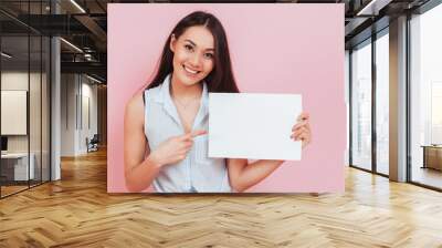 Young attractive woman holding blank billboard with copy space Wall mural