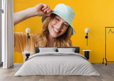 Young blonde woman wearing panama smiling and looking aside Wall mural