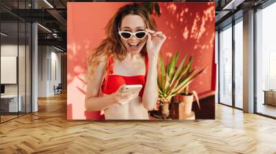 Young cheerful woman wearing sunglasses and bikini Wall mural