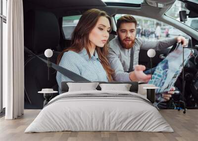 Young couple in car with map Wall mural