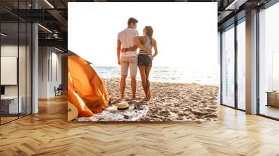 Young cute loving couple hugging on the beach outdoors. Wall mural