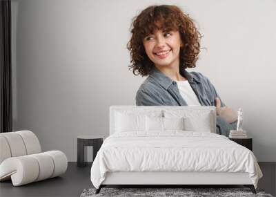 Young ginger woman in shirt smiling and looking aside Wall mural