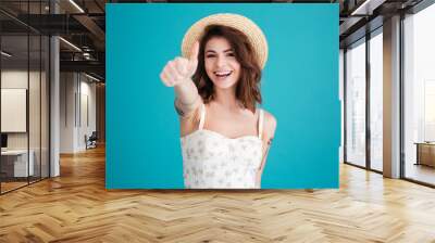 Young girl wearing beach hat and showing thumbs up gesture Wall mural