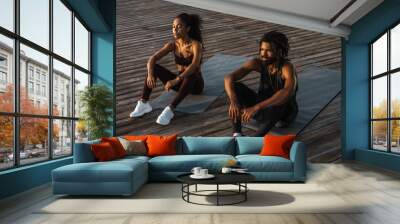 Young happy african american man and woman doing workout outdoors Wall mural