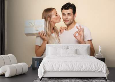 Young loving couple. Man gives a gift surprise box to his girlfriend isolated. Wall mural