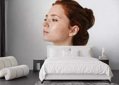 Young redhead woman posing isolated over white wall background. Wall mural