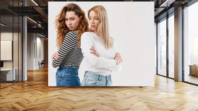 Young two women standing back to back after argument Wall mural