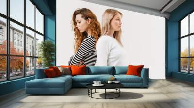 Young two women standing back to back after argument Wall mural