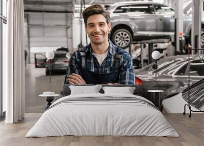 Young white car mechanic smiling while standing in garage indoors Wall mural