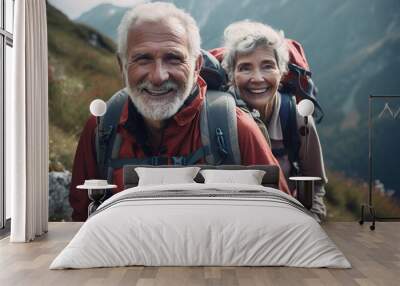 Elderly happy couple with backpacks hiking in the mountains Wall mural