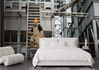 An industry worker descending the stairs on silo. Wall mural