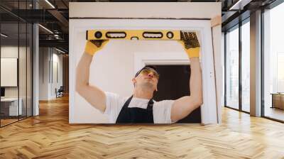 Maintenance man fixing doors with instruments Wall mural